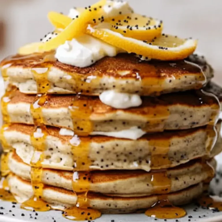 brazilian lemon poppyseed pancakes stacked with syrup and cream